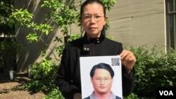遭中国拘禁台湾人权工作者李明哲之妻李净瑜抱着李明哲像 (2017年5月17日,美国之音钟辰芳拍摄)