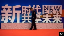 一名警卫在上海中国国际进口博览会的口号前走过。(2018年11月5日)