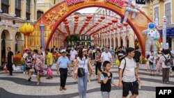这张照片拍摄于2023年10月3日,显示中国游客在10月初为期一周的假期期间走过澳门的塞纳多广场。(法新社)