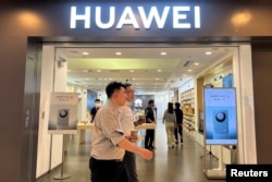 北京一家商场的华为商店展出Mate 60系列手机的广告。(2023年8月30日)
