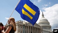 一名LGBT权利支持者举着“平等旗”参加民主党众议员乔·肯尼迪的集会,抗议特朗普总统不许跨性别者服役的禁令。(2017年7月26日)
