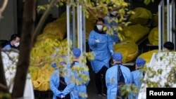 资料照:上海一个殡葬馆的工作人员与停尸房内的尸体。(2023年1月4日)