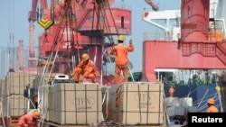 资料照:中国工人在连云港装卸进出口货物。(2019年6月7日)