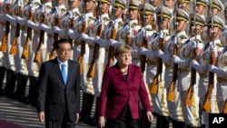 资料照片: 2015年10月29日德国总理默克尔应邀访问中国,在欢迎仪式上由中国国务院总理李克强陪同检阅三军仪仗队。
