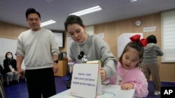 韩国首尔一对母女在一处投票站为国会议员选举投票。(2024年4月10日)