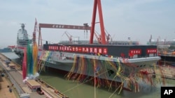 资料照:中国官媒央视播放中国第三艘航空母舰福建舰下水仪式的新闻。(2022年6月17日)