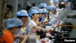 资料照:中国深圳一家工厂的工人在生产线上制造吸尘器。(2019年8月9日)