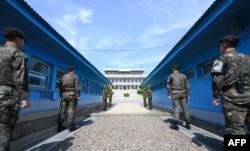 .2018年4月26日,在韩国和朝鲜之间的非军事区板门店休战村的军事分界线前面,站着韩国士兵(前)和朝鲜士兵(后)。美国总统川普已经表示,首脑会议的日期和地点已经选定,他还说分割朝鲜的非军事区可能是一个好地方。
