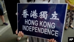 在香港警察总部前抗议的民众手持香港独立的标语。(2018年9月25日)