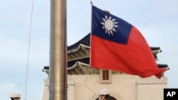两名台湾卫兵在台北中正纪念堂自由广场举行的每日升旗仪式上降下国旗。(美联社:2023年10月10日)