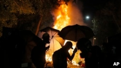 香港中文大学的学生在与警察的冲突中走过火堆。(2019年11月12日)
