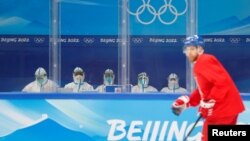 身穿防护服的中国医护人员在北京观看捷克冰球队练习。(2022年1月29日)