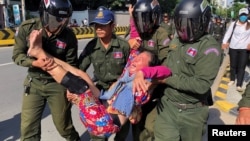在中国驻金边大使馆外柬埔寨警察抬走一名抗议中国在柬埔寨设立军事基地计划的妇女。(2020年10月23日)