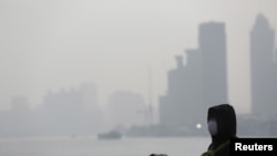 在上海空气污染严重的一天,民众带着防护口罩游览外滩