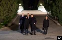 2014年11月11日美国总统奥巴马和中国国家主席习近平在北京举行私人晚宴前在中南海散步,其他人是他们的翻译。