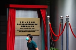一名男子走过香港一家酒店外北京新设的驻港国安公署的牌子。(2020年7月8日)
