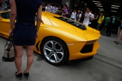 资料照:一名女子站在2012年上海车展的兰博基尼跑车旁。