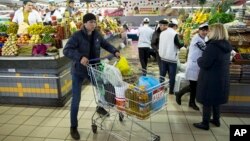 俄罗斯莫斯科,一名男子在一家杂货店推着装有食品的手推车(2015年4月2日)。