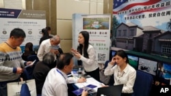 资料照:中国参观者在投资美国峰会的展位上了解有关美国政府EB-5签证项目的信息。(2017年5月7日)