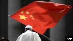 当教宗方济各在梵蒂冈圣彼得广场结束对信众的每周讲话离开时,一人向他展示中国国旗。(2019年6月12日)