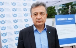 在联合国日内瓦总部外,世界维吾尔代表大会主席多里昆·艾沙站在得到美国政府支持的图片展前。(2021年9月16日)