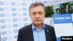 在联合国日内瓦总部外,世界维吾尔代表大会主席多里昆·艾沙站在得到美国政府支持的图片展前,该图片展反映据称被关押在中国新疆拘留营或失踪的维吾尔人 (2021年9月16日)