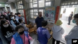 2022年11月26号,居住在台湾新北市的选民在附近的排队投票。参选的民众对将于2024年选出新总统这次投票哪个党派将获得更多支持非常关注。