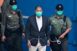 资料照:香港壹传媒集团创办人黎智英在港警看押下走向法庭。(2020年12月12日)