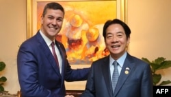资料照:2023年8月14日,台湾时任副总统赖清德在访问巴拉圭期间与时任巴拉圭当选总统圣地亚哥·潘尼亚(Santiago Pena)左)握手。