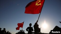 中国解放军军人在内蒙古朱日和训练基地准备参加阅兵,庆祝解放军建军90周年。中共党旗在前,国旗居中,军旗在后(2017年7月30日)
