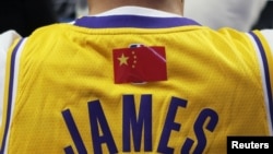 资料照片:NBA超级明星勒布朗·詹姆斯的中国球迷身穿有他名字的背心观看洛杉矶湖人队和布鲁克林篮网队在上海的比赛。(2019年10月10日)