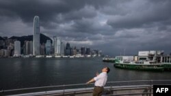 在超强台风“摩羯”经南中国海扑向中国南部海岸之际,一位男子在香港维多利亚港的长廊仰视天空。(2024年9月5日)