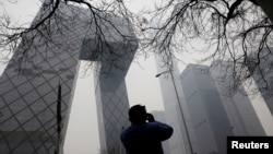 一名男子用手机拍摄北京的中国央视大楼。(2021年3月5日)