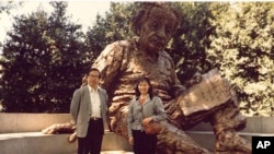 李淑娴和方励之1986年在华盛顿的美国科学院大门前的爱因斯坦雕像前合影。爱因斯坦手上的一张纸写有三个公式(从下到上):E=mc2;光电效应;广义相对论方程。注意:广义相对论方程中没有宇宙常数项