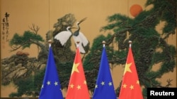 资料照:2016年7月12日,在北京人民大会堂举行的中欧领导人峰会上竖立的欧盟和中国的旗帜。(路透社)