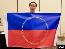 陈维明在会场展示他设计的未来中国旗帜(美国之音包小祥拍摄)