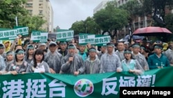 民进党主席卓荣泰(中间持麦克风者)率领民进党成员冒雨参加“929台港大游行”。(民进党提供)