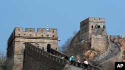 中国北京,在新型冠状病毒爆发后重新开放的八达岭长城上,游客戴着防护口罩行走。随着新的冠状病毒感染病例数量急剧下降,北京的城市动物园和中国长城的部分地区对提前预订的游客重新开放(2020年3月24日)。