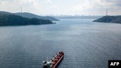 资料照片:2022年8月3日,一张鸟瞰图显示,悬挂塞拉利昂国旗的拉佐尼号货船在接受正式检查后,正沿着博斯普鲁斯海峡驶往黎巴嫩的黎波里,该货船载有来自乌克兰的粮食。