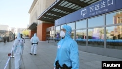 中国吉林省吉林市身穿防护服的警察站在停运的火车站进站口处。(2020年5月13日)