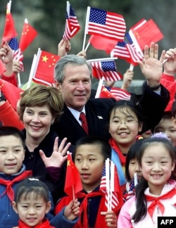 2002年2月22日亚洲之行最后一站: 美国总统乔治·W·布什(右)和第一夫人劳拉·布什(左)访问中国八达岭长城。