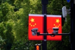 上海一家商场悬挂的中国国旗和国旗前的监控摄像头。(2021年5月5日)