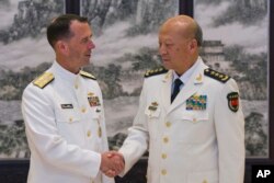 美国海军作战部长理查森和中国海军司令吴胜利在北京的中国海军总部握手(2016年7月18日)