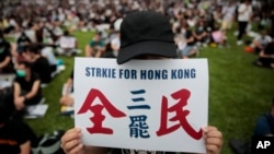 一名香港抗议者手举“全民三罢”的标语参加反送中集会。(2019年9月2日)