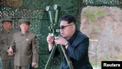 朝鲜领导人金正恩视察战略潜水艇水下弹道导弹试射场地。(朝鲜官方朝中社2016年4月24日在平壤发布这张没有具体日期的照片)