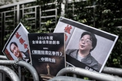 资料照:香港抗议者在北京驻香港机构中联办前手举铜锣湾书店失踪老板桂民海的照片。 (2016年1月19日)