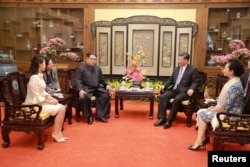 中国国家主席习近平和夫人彭丽媛,朝鲜国务委员会委员长金正恩和夫人李雪主在北京会见(2018年3月28日发布的照片)。