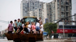 河南郑州暴雨后居民乘坐斗车疏散。(2021年7月23日)