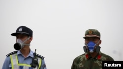 在天津大爆炸现场头带防毒面具的中国警察和武警士兵 (2015年8月18日)