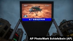 北京街头一家商场的大屏幕正在播放中国官媒报道中国火星探测器天问一号成功登陆火星的视频。(2021年5月15日)